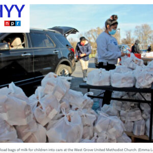 Volunteers load bags of milk for children into cars at the West Grove United Methodist Church. (Emma Lee/WHYY)