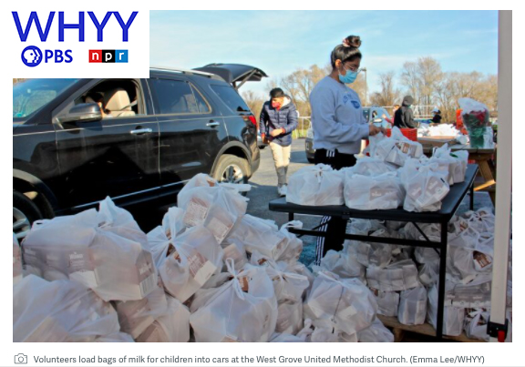 Volunteers load bags of milk for children into cars at the West Grove United Methodist Church. (Emma Lee/WHYY)